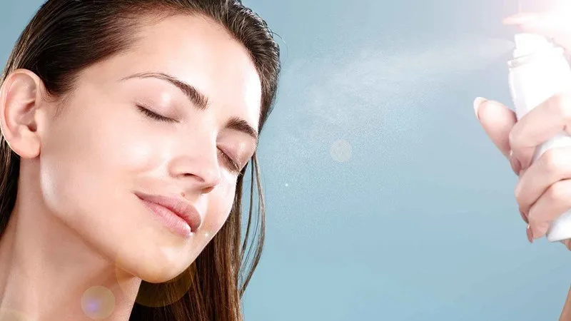 Hình ảnh cô gái tươi tắn xịt khoáng lên mặt, minh họa công dụng cấp ẩm và cân bằng pH da từ các loại nước xịt khoáng tự chế.