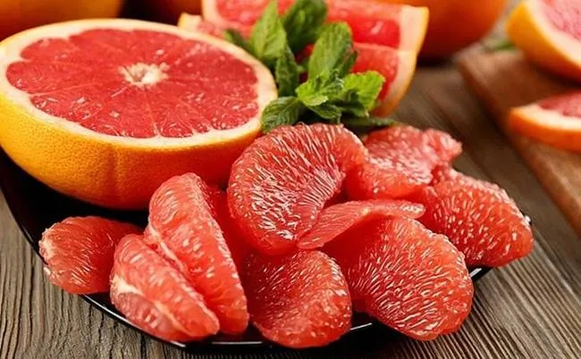 Bưởi hồng tươi bổ đôi, với múi bưởi căng mọng chứa nhiều vitamin