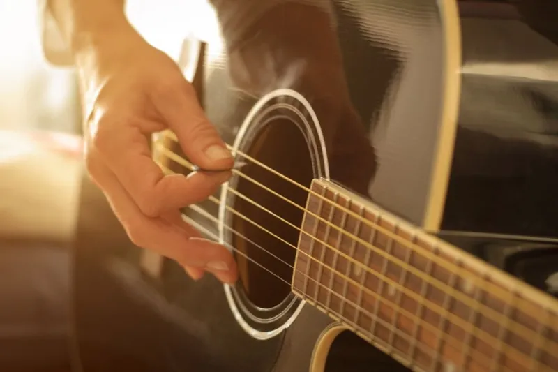 Dây đàn guitar rung động tạo ra âm thanh, minh họa dao động tự do